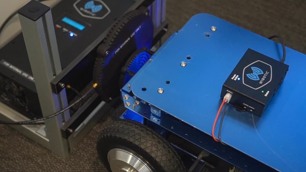 Custom wireless charging setup with transmitter and receiver coils aligned on a mobile robot platform
